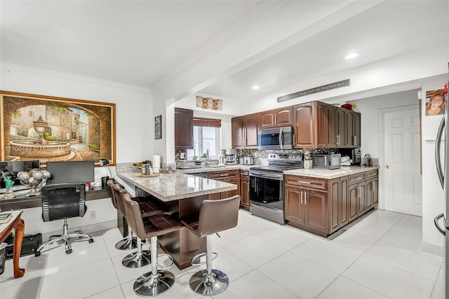 kitchen featuring kitchen peninsula, light stone counters, a breakfast bar, stainless steel appliances, and light tile patterned floors