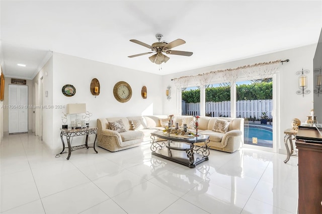 tiled living room with ceiling fan and ornamental molding