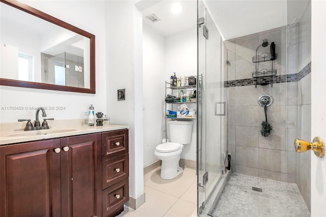 bathroom with tile patterned floors, vanity, toilet, and a shower with shower door