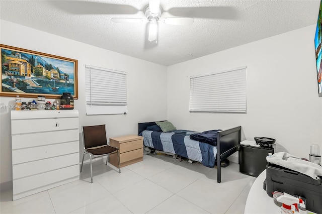 bedroom featuring light tile patterned floors, a textured ceiling, and ceiling fan