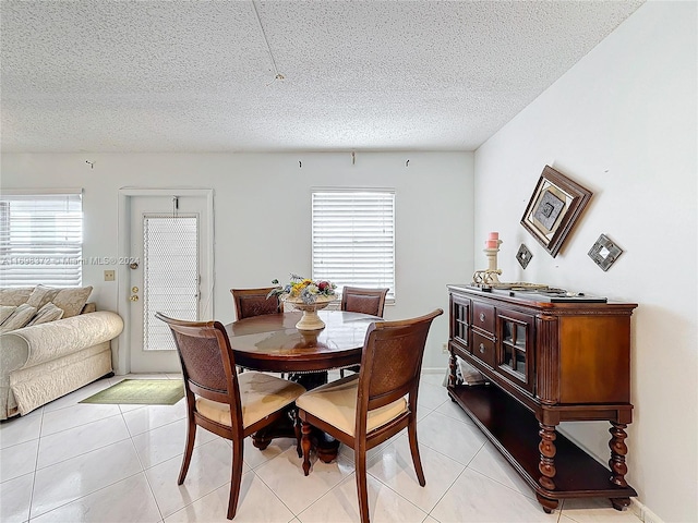 tiled dining room featuring a textured ceiling and a wealth of natural light