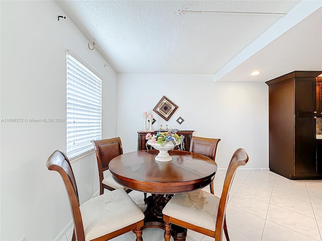 dining area featuring light tile patterned floors and a textured ceiling