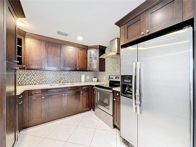 kitchen with sink, wall chimney range hood, decorative backsplash, light tile patterned floors, and appliances with stainless steel finishes