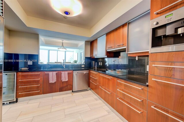 kitchen featuring appliances with stainless steel finishes, backsplash, a raised ceiling, beverage cooler, and sink