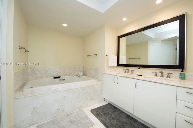 bathroom with tile patterned flooring, vanity, and tiled bath