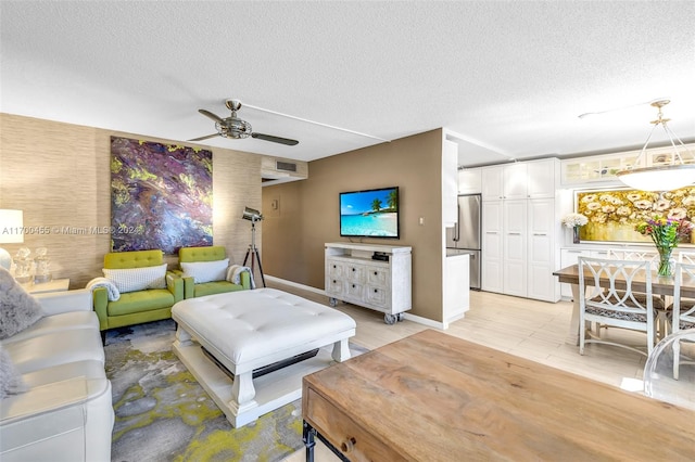 living room with ceiling fan and a textured ceiling