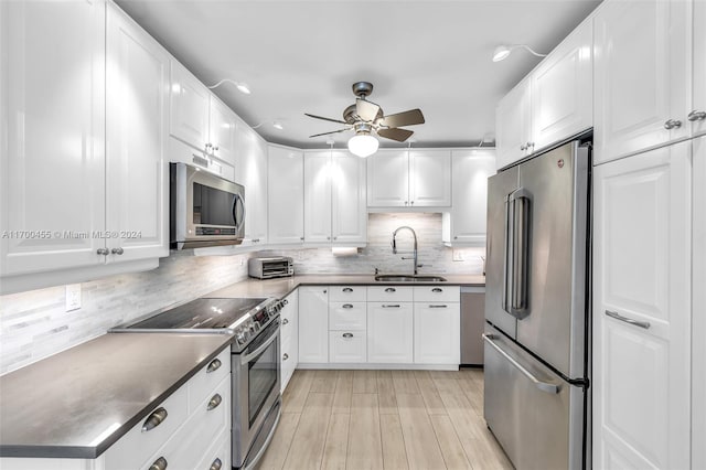 kitchen with sink, white cabinets, and stainless steel appliances