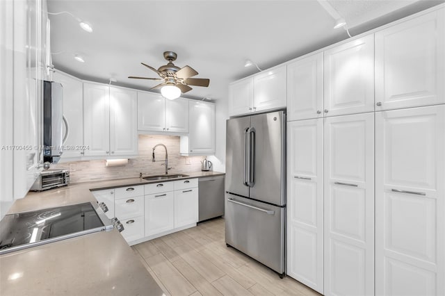 kitchen with white cabinets, sink, light hardwood / wood-style flooring, ceiling fan, and appliances with stainless steel finishes