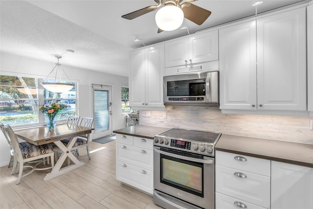 kitchen featuring white cabinets, stainless steel appliances, and a wealth of natural light