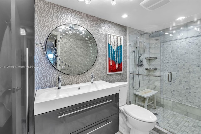 bathroom featuring vanity, an enclosed shower, and toilet