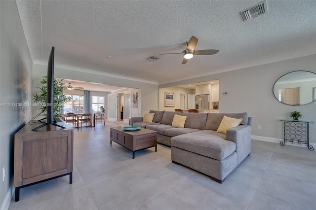 living room featuring ceiling fan and a textured ceiling