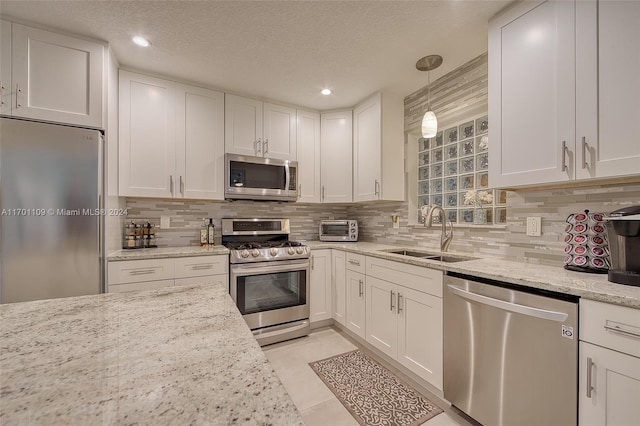 kitchen featuring white cabinets, sink, appliances with stainless steel finishes, and a textured ceiling