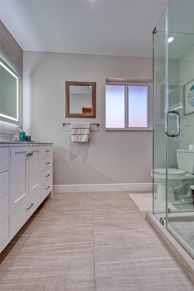 bathroom with an enclosed shower, vanity, and toilet