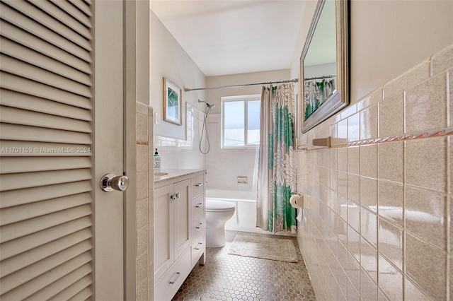 full bathroom featuring shower / bath combination with curtain, vanity, toilet, and tile walls