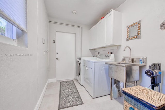 clothes washing area with sink, cabinets, and independent washer and dryer