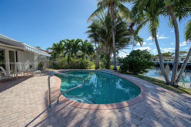 view of swimming pool with a water view and a patio