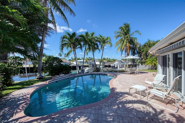 view of swimming pool featuring a water view and a patio area