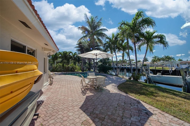 view of patio / terrace with grilling area, a dock, and a water view