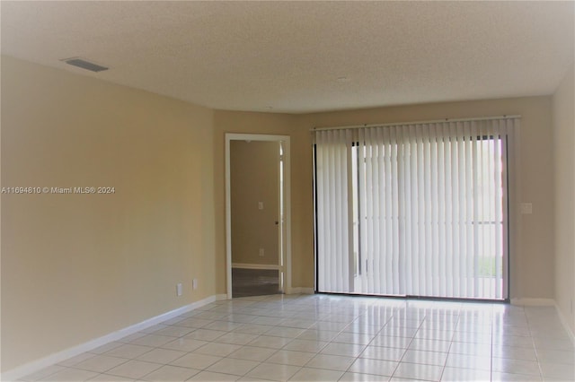 tiled spare room with a textured ceiling