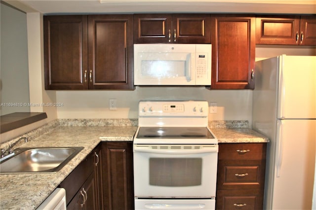 2531 NW 56th Ave Unit 109, Lauderhill, FL 33313 - kitchen featuring white appliances and dark brown cabinetry