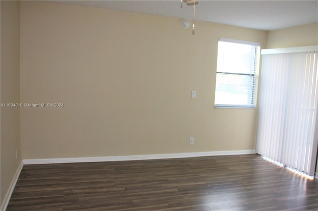 spare room featuring a textured ceiling and dark hardwood / wood-style floors