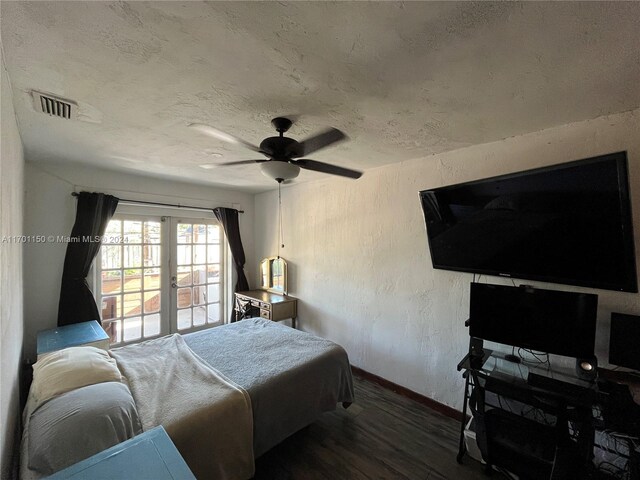 bedroom with ceiling fan, french doors, dark wood-type flooring, and a textured ceiling