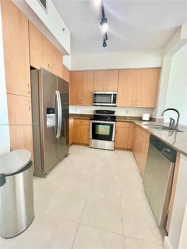 kitchen featuring appliances with stainless steel finishes, sink, track lighting, and light tile patterned flooring