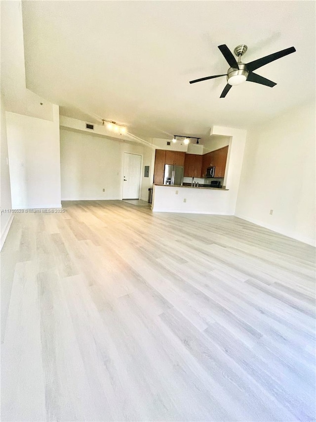 unfurnished living room featuring ceiling fan, light wood-type flooring, and track lighting