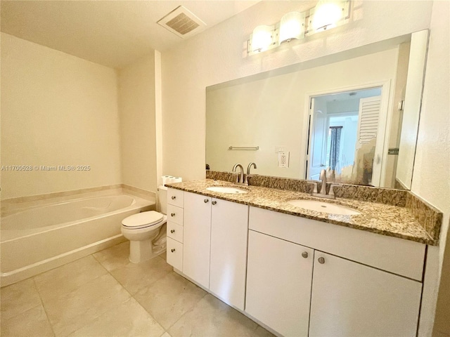 bathroom featuring toilet, a tub, tile patterned floors, and vanity