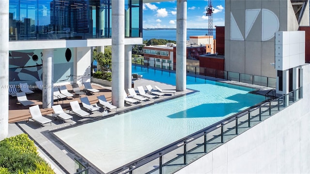 view of swimming pool with a patio area and a water view