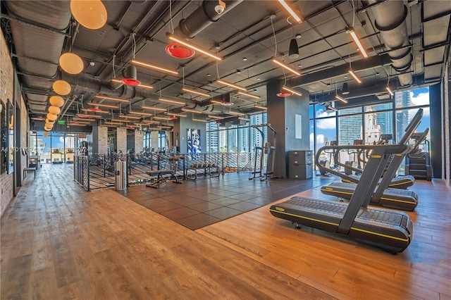 gym with a wall of windows and hardwood / wood-style floors