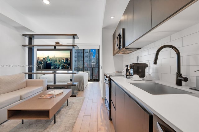 kitchen featuring stainless steel appliances, decorative backsplash, and sink