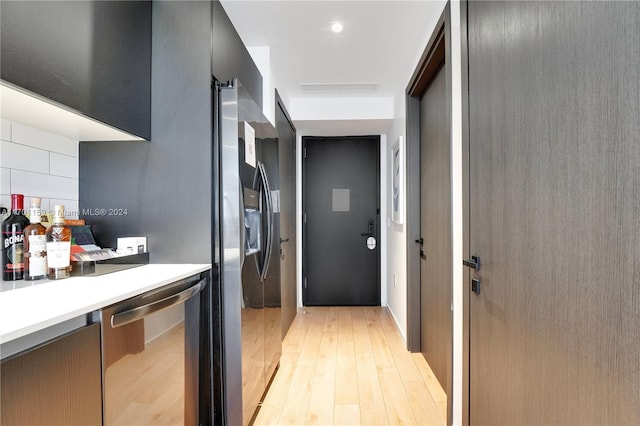 kitchen with appliances with stainless steel finishes and light hardwood / wood-style flooring