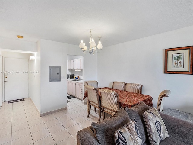 dining area with an inviting chandelier, electric panel, and light tile patterned flooring