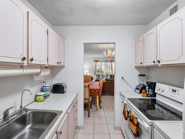 16701 NE 13th Ave Unit 101, Miami, FL 33162 - kitchen with electric stove, white cabinets, light countertops, and a textured ceiling