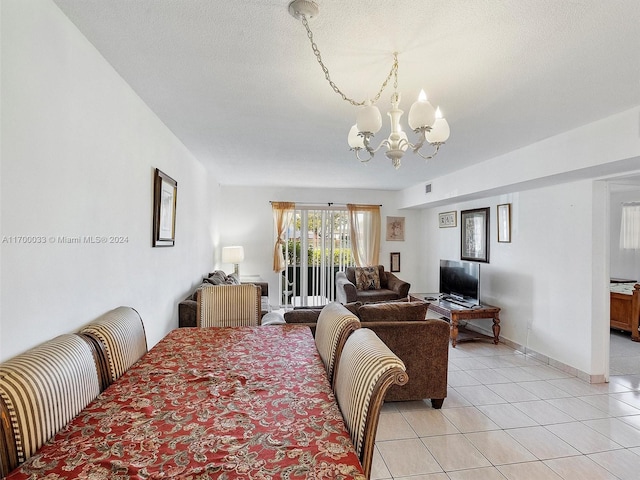 tiled dining room with a chandelier and a textured ceiling