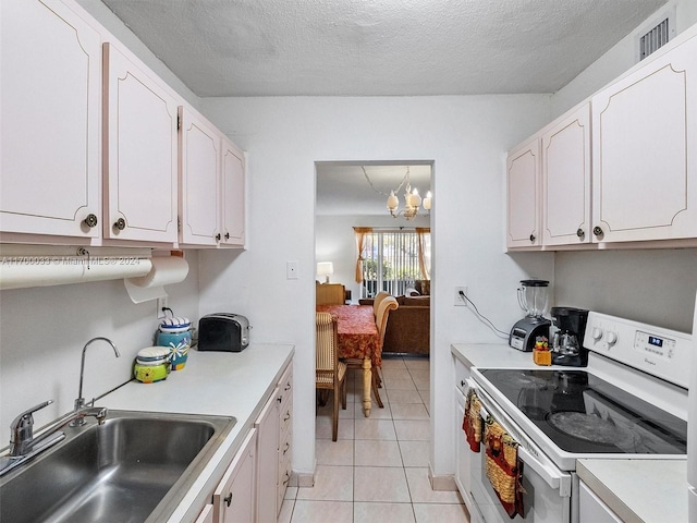 kitchen with sink, light tile patterned floors, white electric stove, a chandelier, and white cabinetry