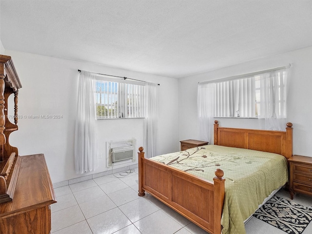 tiled bedroom featuring a wall mounted air conditioner and a textured ceiling