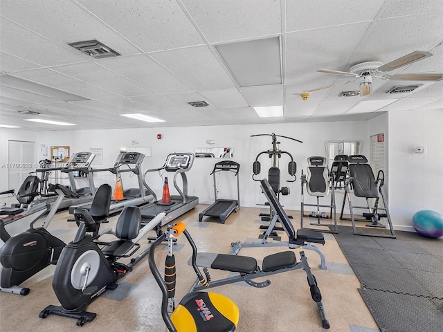 workout area with a ceiling fan, visible vents, and a paneled ceiling