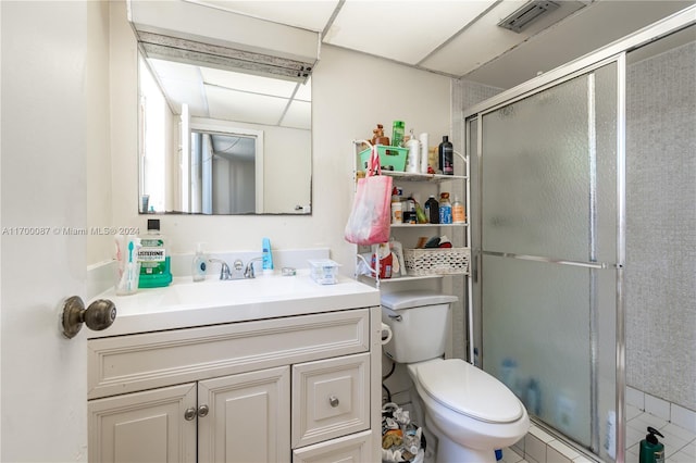 bathroom with tile patterned flooring, vanity, toilet, and a shower with door