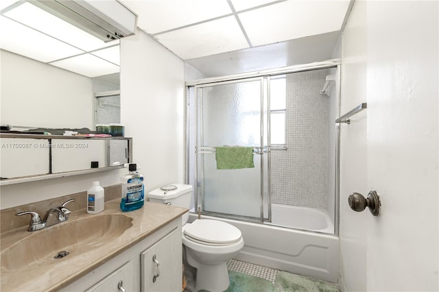 full bathroom with a paneled ceiling, vanity, toilet, and enclosed tub / shower combo