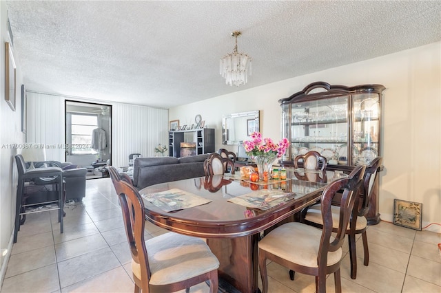 dining area featuring light tile patterned flooring and a textured ceiling