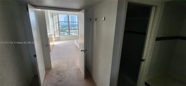 hallway featuring light colored carpet