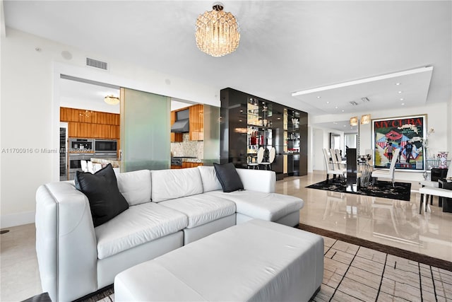 living room with light tile patterned floors and a notable chandelier