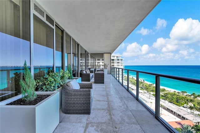 balcony featuring a water view and a view of the beach