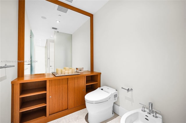 bathroom with vanity, toilet, and a bidet