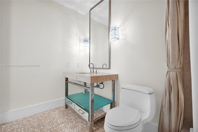 bathroom with toilet, tile patterned floors, and sink