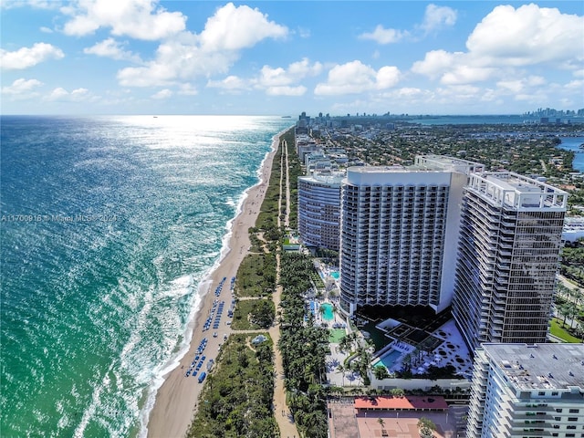 birds eye view of property with a water view and a beach view