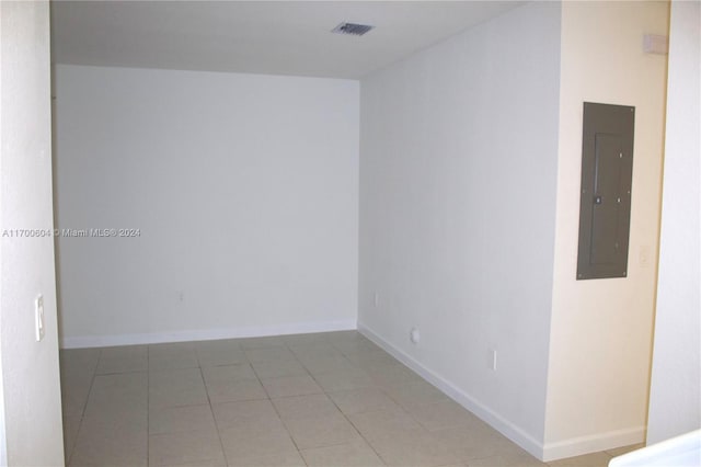 empty room featuring electric panel and light tile patterned floors