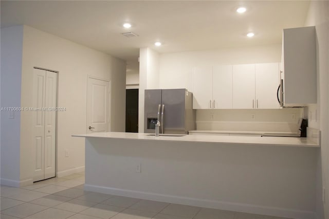 kitchen featuring white cabinets, sink, appliances with stainless steel finishes, light tile patterned flooring, and kitchen peninsula